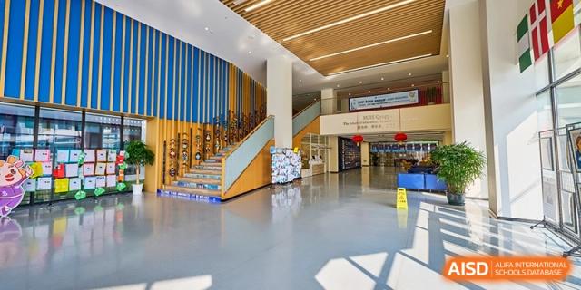 The bright school lobby features a wide staircase and modern architectural details for a welcoming entrance at Shanghai United International School, Qingpu Campus