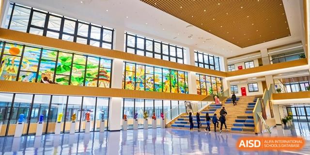 Spacious school lobby with colorful stained glass and modern architecture at Shanghai United International School,Qingpu Campus