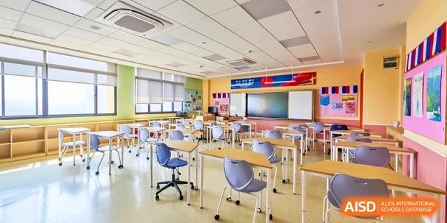Modern classroom featuring blue chairs and white desks for students at Shanghai United International School,Qingpu Campus