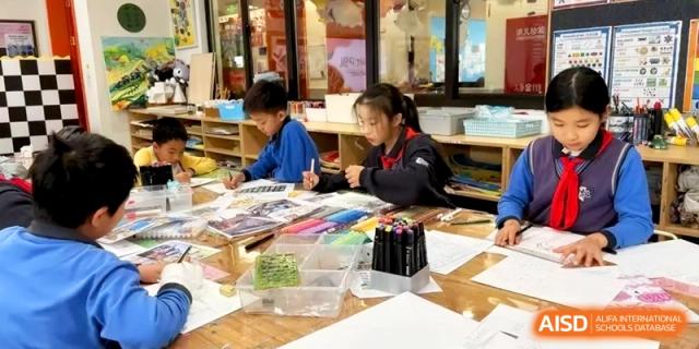Group of young students engaged in an art and craft project at a table at Shanghai United International School,Qingpu Campus