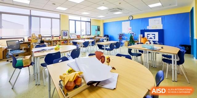 Bright and organized elementary classroom with supplies on the tables at Shanghai United International School,Qingpu Campus