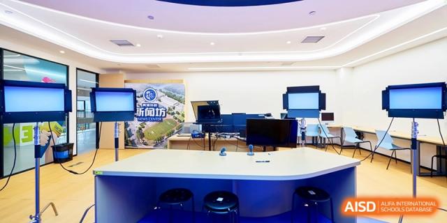 High-tech media room with screens and a curved desk for student use at Shanghai United International School,Qingpu Campus
