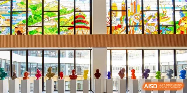 Colorful art display featuring sculptures and stained glass by a window at Shanghai United International School,Qingpu Campus