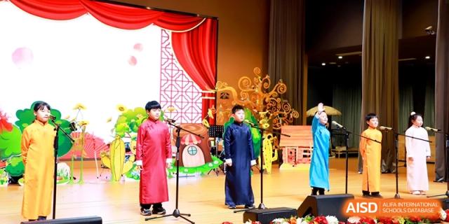 Two students dressed in traditional robes perform a vocal piece on a decorated stage during a school event at Shanghai United International School,Qingpu Campus.