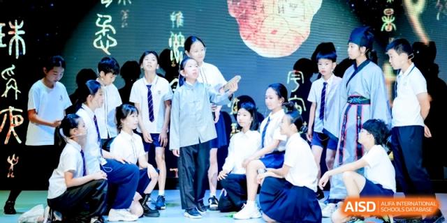 Students performing on stage in traditional and school uniforms during a theatrical production at HT Nanjing Impact Academy.