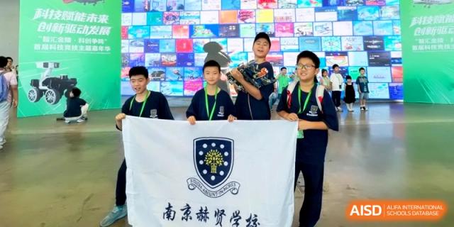 A group of students proudly holding a school banner with a crest during a campus event at HT Nanjing Impact Academy.