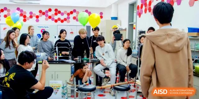 Students observe a science experiment with balloons in a classroom laboratory at the International School of Tianjin.