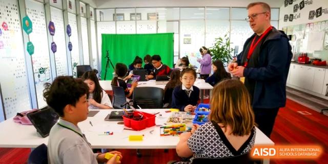 Students engage in creative activities and media production using a green screen and building blocks in a flexible workspace at the International School of Tianjin.