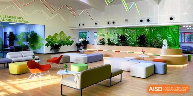 A bright, modern student lounge area with green and white modular seating at the International School of Tianjin.