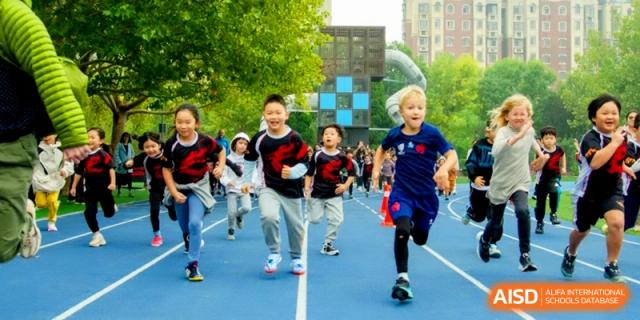 Enthusiastic students race down the blue athletic track during a competitive field day at the International School of Tianjin.