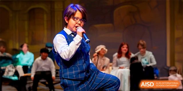 A boy performs a dramatic musical number on stage during a school talent showcase at the International School of Tianjin.