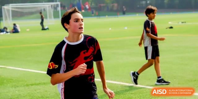 A student in a school sports jersey looks across the field during an intense soccer game at the International School of Tianjin.