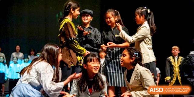 Students in theatrical costumes act out a scene during a collaborative drama performance at the International School of Tianjin.