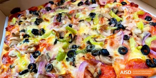 A delicious vegetarian pizza topped with olives, peppers, and onions at the International School of Tianjin.