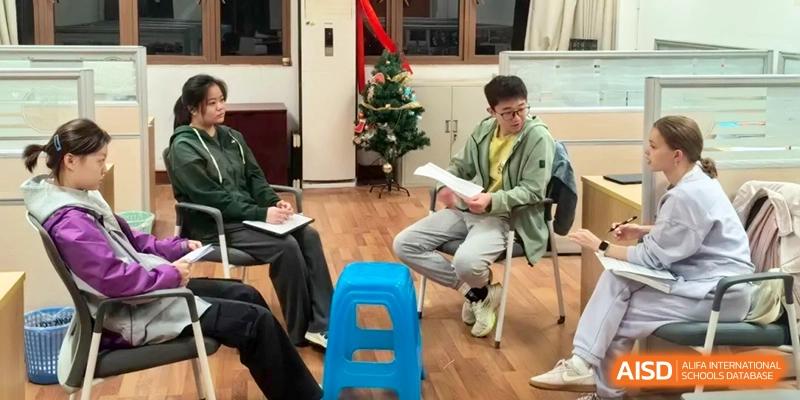 Students participate in a group discussion while seated in a circle in a decorated common room at Xishan Senior High School.