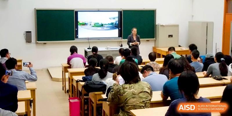 A female teacher leads a presentation in front of a classroom filled with students using an interactive monitor at Xishan Senior High School.
