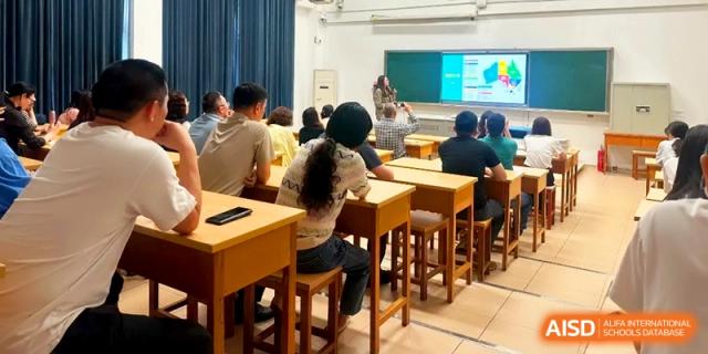 Students and parents sit at wooden desks during an informative school meeting in a bright classroom at Xishan Senior High School.