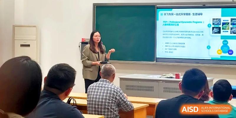 A female teacher presents a lesson using a digital slideshow to a group of seated students at Xishan Senior High School.