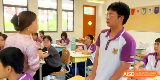 A male student stands to answer a question during a lively classroom discussion with his peers at Xishan Senior High School.