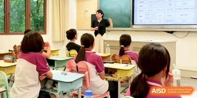 A teacher gestures toward a digital screen while addressing students seated at their desks at Xishan Senior High School.