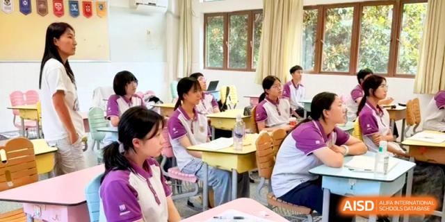 A classroom of students in purple and white uniforms focus on a lesson during a school day at Xishan Senior High School.