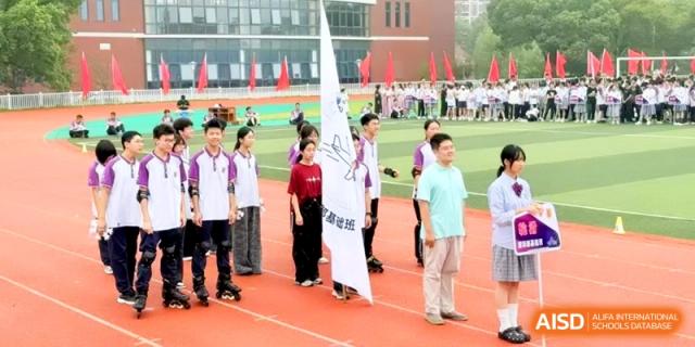 Students stand on the track holding a large white flag during the opening ceremony of a sports meet at Xishan Senior High School.