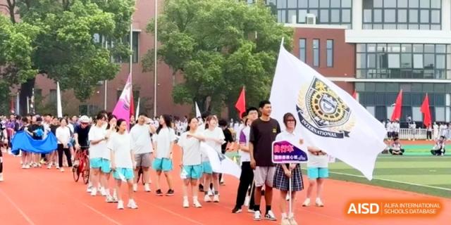A group of students gathers on the track with school flags during an outdoor cultural festival at Xishan Senior High School.