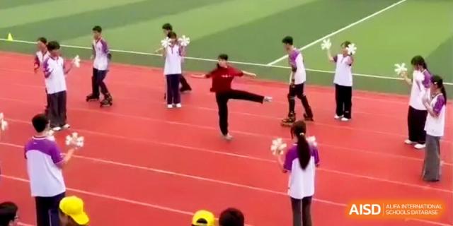 A student performs a dance move on the track while others watch during a cultural performance at Xishan Senior High School.