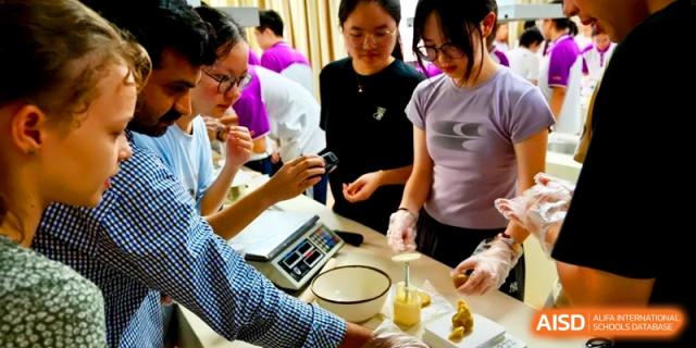 Students work together at a kitchen station to press dough into intricate mooncake molds at Xishan Senior High School.
