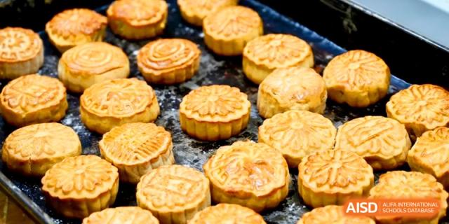 A tray of golden-brown, freshly baked mooncakes with traditional patterns is ready for serving at Xishan Senior High School.