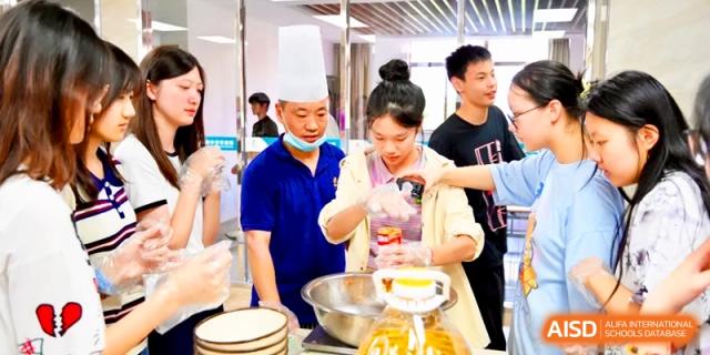 A chef and several students gather around a kitchen island to prepare large batches of food at Xishan Senior High School.