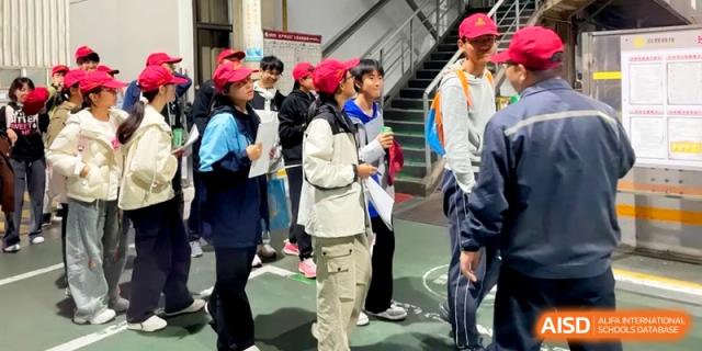 Students wearing red caps and white jackets gather outdoors for a field trip or school activity at Kunshan Senior High School.
