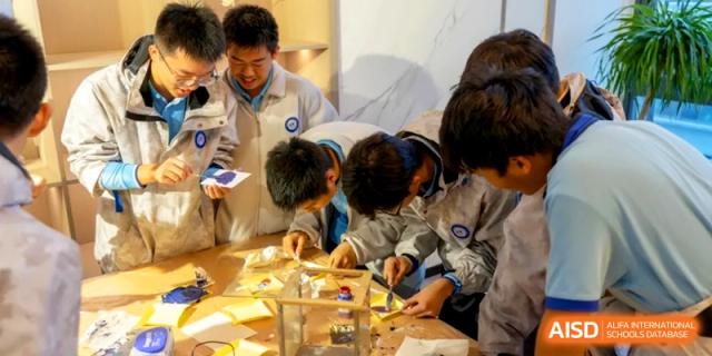Students huddle around a table to participate in a hands-on science or engineering workshop at Kunshan Senior High School.