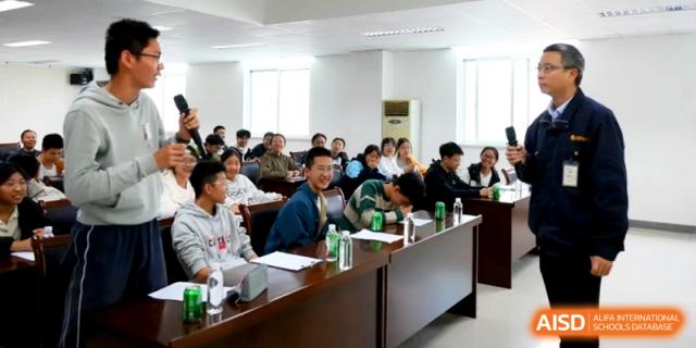 Students sit at a long wooden table in a conference room during a seminar or meeting at Kunshan Senior High School.