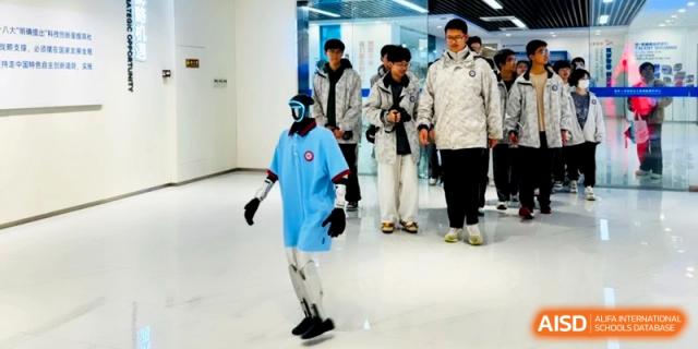A student demonstrates a wearable robotic or technological device in front of classmates at Kunshan Senior High School.