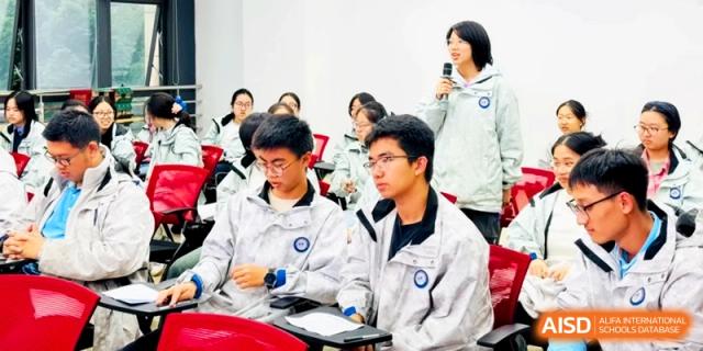 Students in white uniforms sit at desks and take notes during a classroom lecture at Kunshan Senior High School.