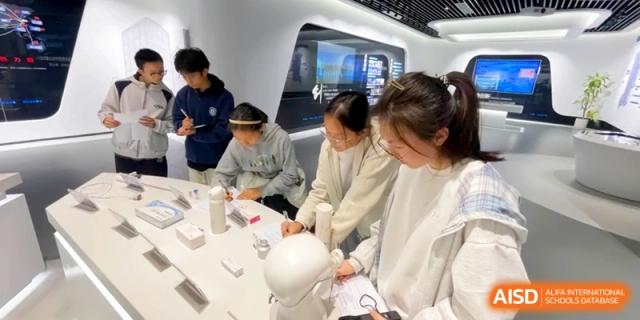 Students explore and interact with scientific exhibits in a brightly lit, modern laboratory at Kunshan Senior High School.