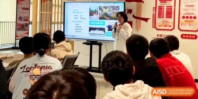 A teacher stands by a television screen giving a digital presentation to a group of students at Kunshan Senior High School.