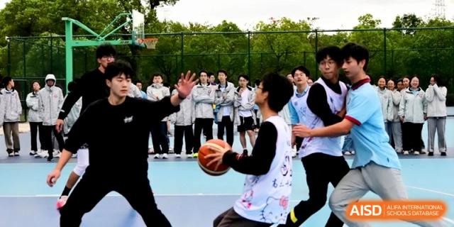 Students compete in a basketball game on an outdoor court during a sports event at Kunshan Senior High School.