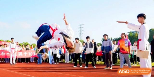 An athlete performs an impressive mid-air flip during a martial arts or gymnastics display at Kunshan Senior High School.