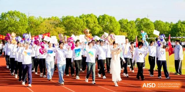 Students in white shirts march together during an opening parade on the sports field at Kunshan Senior High School.