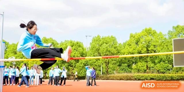 A student athlete is captured mid-air while attempting a high jump over a bar at Kunshan Senior High School.