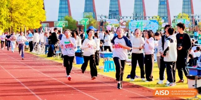 Female students compete in a spirited running race on the red outdoor track at Kunshan Senior High School.