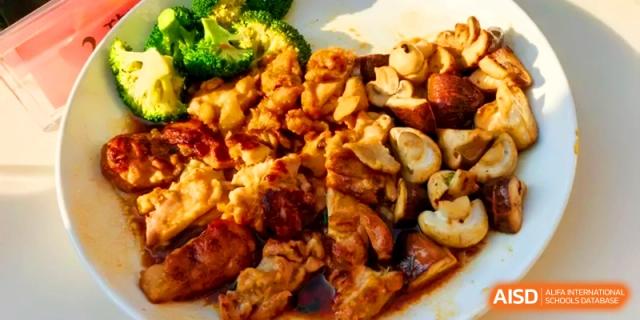 A hearty dish of braised chicken pieces served with mushrooms and broccoli at Kunshan Senior High School.