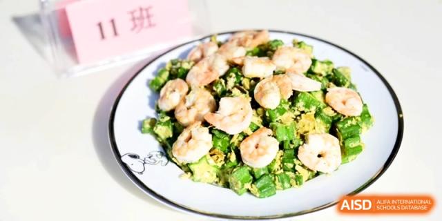 A fresh plate of stir-fried shrimp served with bright green vegetables on a white patterned plate at Kunshan Senior High School.