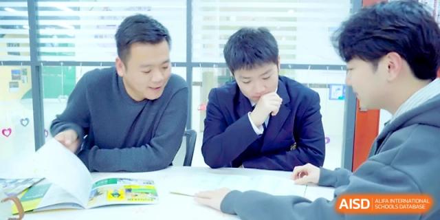 A student and a teacher engage in a one-on-one tutoring session over a shared desk at Maple Leaf International School - Xi_an.