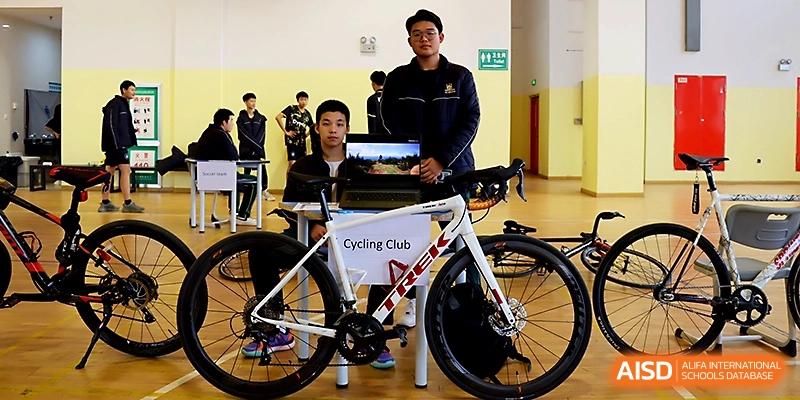 Two students proudly display a professional racing bicycle as part of a school cycling club at Maple Leaf International School - Xi_an.