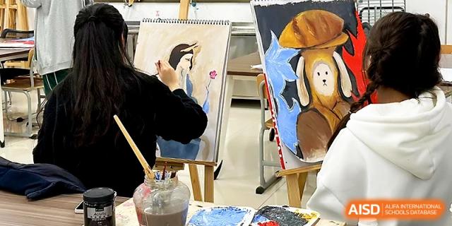 A student paints a detailed portrait on an easel during a creative fine arts class session at Maple Leaf International School - Xi_an.