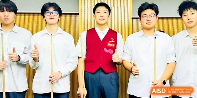 Three male students standing together, with the center student wearing a red vest, at Maple Leaf International School - Xi_an.