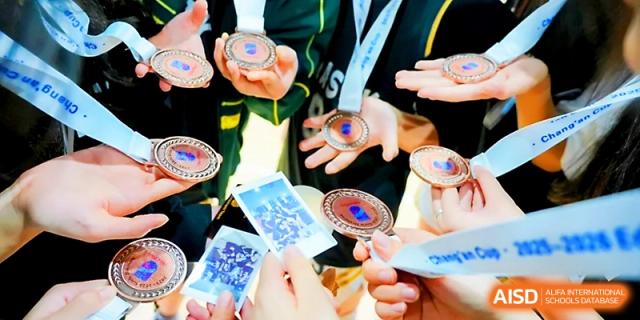 Close-up of students holding and displaying their bronze participation medals at Maple Leaf International School - Xi_an.